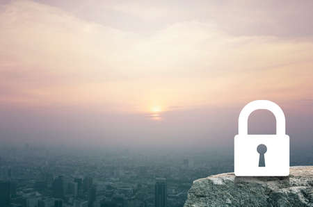 Key icon on rock over aerial view of cityscape at sunset, vintage style, Business security conceptの写真素材