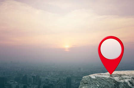 Map pin location button on rock over aerial view of cityscape at sunset, vintage style, Map pointer navigation conceptの写真素材