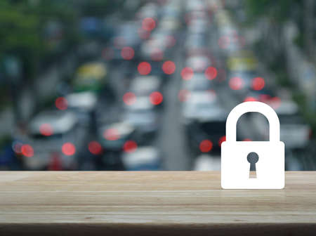 Key icon on wooden table over blur of rush hour with cars and road, Business security conceptの写真素材