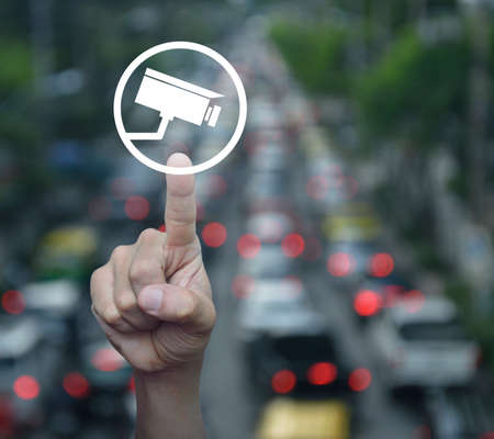 Hand pressing car flat icon over blur of rush hour with cars and road, Business transportation taxi car service conceptの写真素材
