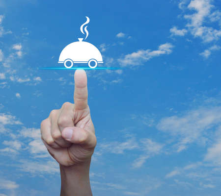 Hand pressing restaurant cloche flat icon over blue sky with white clouds, Food delivery conceptの写真素材