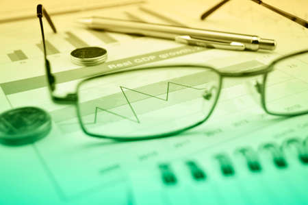 Growth financial graph with eye glasses, coins and pen, Business success conceptの写真素材
