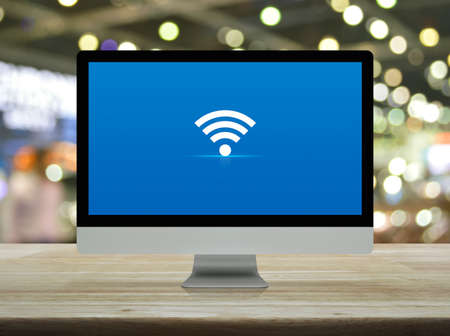 flat icon on desktop modern computer monitor screen on wooden table over blur light and shadow of shopping mall, Technology internet online conceptの写真素材