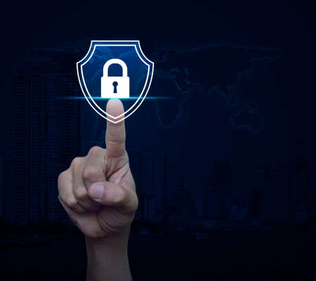 Hand pressing padlock with shield flat icon over world map, modern city tower and skyscraper,...