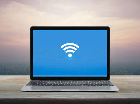 flat icon with modern laptop computer on wooden table over office city tower and skyscraper at sunset sky, vintage style, Technology internet online conceptの写真素材
