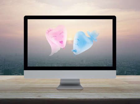 Bride and Groom love heart balloon shape with desktop modern computer monitor screen on wooden table...