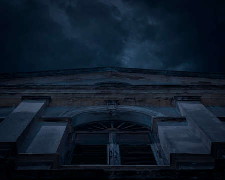 Facade of old ancient architecture building over cloudy spooky sky, Halloween mystery backgroundの写真素材
