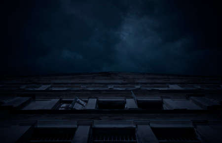 Facade of old ancient architecture building over cloudy spooky sky, Halloween mystery backgroundの写真素材