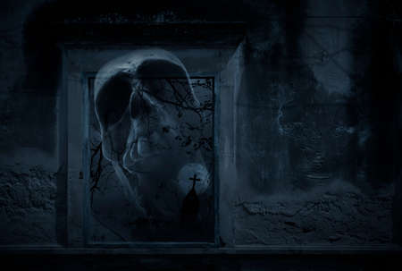 Human skull in old damaged window with wall over cross, church, birds, dead tree and spooky cloudy sky, Halloween mystery conceptの写真素材