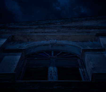 Facade of old ancient window architecture building over cloudy sky, Halloween mystery backgroundの写真素材
