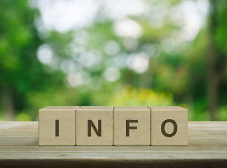 Info letter on block cubes on wooden table over blur green tree in park, Business customer service and support conceptの写真素材