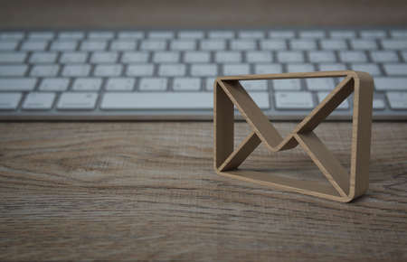 Wood email 3d icon on wooden table with modern computer keyboard, Business customer service and support online conceptの写真素材