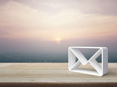 Mail 3d icon on wooden table over modern city tower and skyscraper at sunset sky, vintage style, Business customer service and support online conceptの写真素材