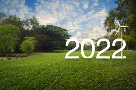 2022 white text with wind turbine on green grass field and trees in public park, Happy new year 2022 ecological cover conceptの写真素材