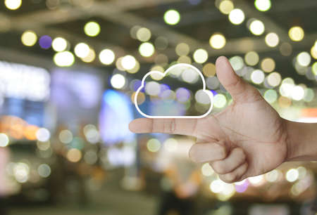 Cloud computing icon with copy space on finger over blur light and shadow of shopping mall, Technology cloud computing conceptの写真素材