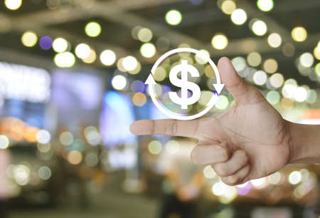Money transfer flat icon on finger over blur light and shadow of shopping mall, Business currency exchange service conceptの写真素材