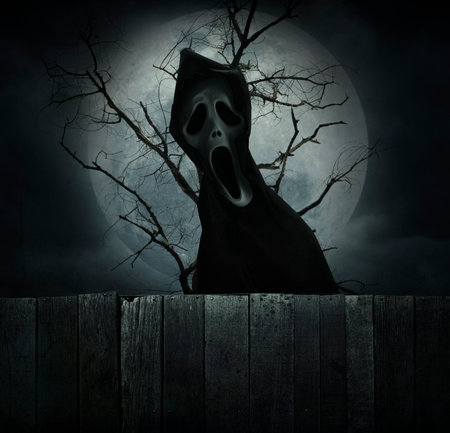 Ghost standing over dead tree, full moon and cloudy spooky sky, Halloween mystery conceptの写真素材