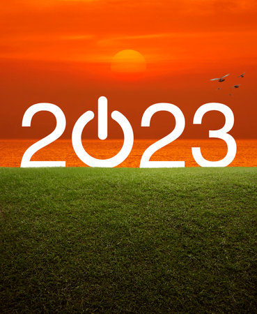 2023 start up business flat icon on green grass field over sunset sky and sea, Happy new year 2023...
