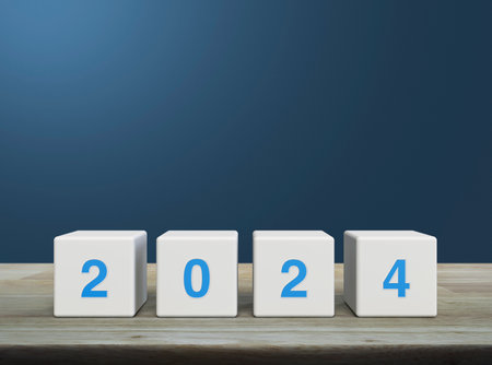 2024 letter on white block cubes on wooden table over light blue wall, Happy new year 2024 cover conceptの写真素材