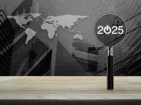 2025 start up icon with magnifying glass on wooden table over world map, modern city tower and...