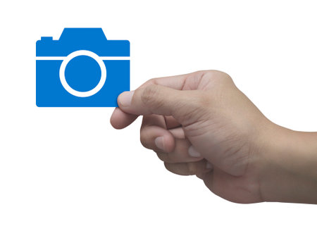 Hand holding camera flat icon in fingers isolated on white background, Business camera service shop online conceptの写真素材