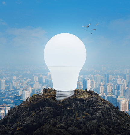 Led light bulb on soil over city tower and skyscraper, Green ecology and saving energy conceptの写真素材
