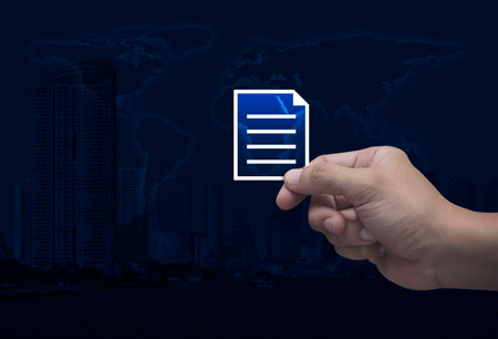 Hand holding document flat icon in fingers over world map, modern city tower and skyscraper, Technology internet online concept, Elements of this image furnished by NASAの写真素材