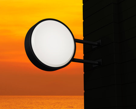 Hanging black rounded signboard mockup over sunset sky and sea, Light box signage, 3D renderingの写真素材