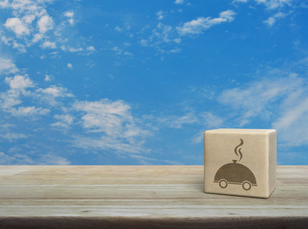 Restaurant cloche flat icon on wood block cube on wooden table over blue sky with white clouds, Business food delivery online conceptの写真素材