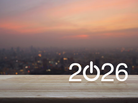 2026 start up business flat icon on wooden table over blur of cityscape on warm light sundown, Happy...