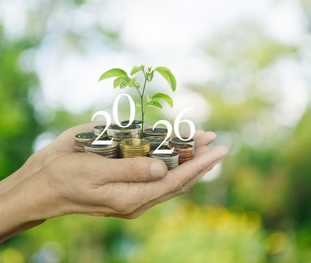 Hands holding growing tree with 2026 white text and coins over blur forest, Happy new year 2026...