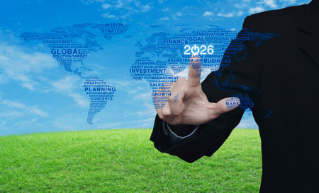 Businessman pressing 2026 start up business icon with global words world map over green grass field with blue sky, Happy new year 2026 global business start up conceptの写真素材