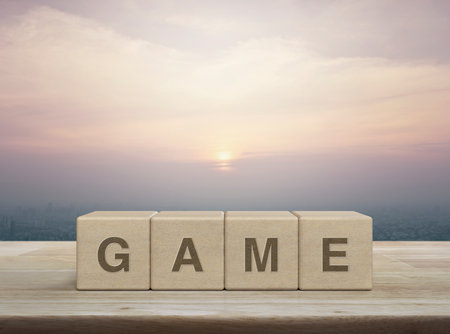 Letters on wood block cubes on wooden table over city at sunset, vintage styleの写真素材