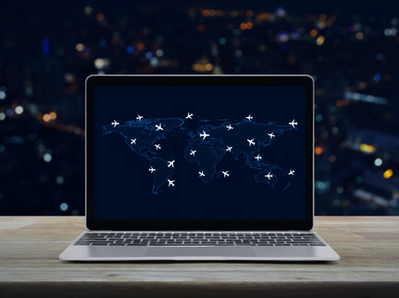 Flight routes airplanes connection and world map on laptop computer screen on table over blur colorful night light office city tower and skyscraper, Business airplane transportation network, Elements of this image furnished by NASAの写真素材