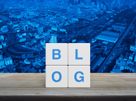 BLOG letter on white block cubes on wooden table over modern city tower, street, expressway and skyscraper, Business communication conceptの写真素材
