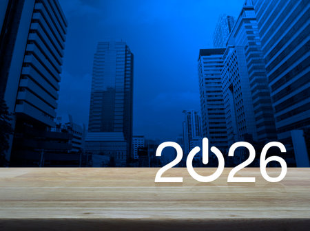 2026 start up business flat icon on wooden table over modern office city tower and skyscraper, Happy...