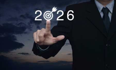 Businessman pressing 2026 letter with goal flat icon over sunset sky, Business happy new year 2026 success conceptの写真素材