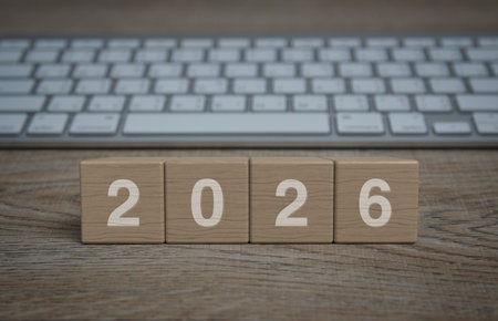 2026 letter on wood block cubes on wooden table with modern computer keyboard, Happy new year 2026 business online conceptの写真素材