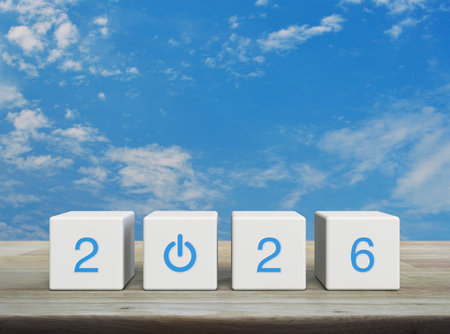 2026 start up business flat icon on white block cubes on wooden table over blue sky with white...
