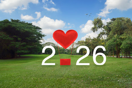 Red fabric heart love air balloon with 2026 white text on green grass and trees in public park, Happy new year 2026 and Valentines day conceptの写真素材