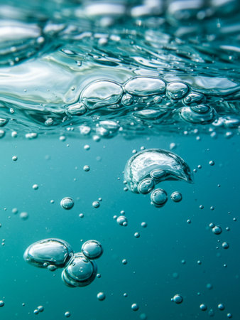 A detailed close-up of bubbles rising in water, showcasing the interplay of light and transparency.の写真素材