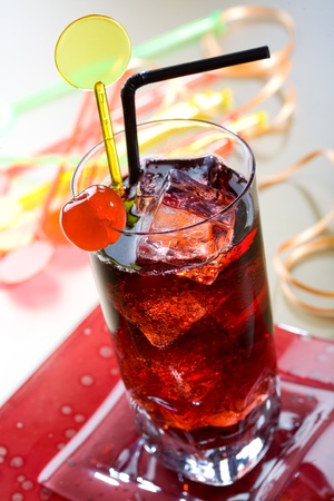 Red drink with ice cubes and black sipperの写真素材