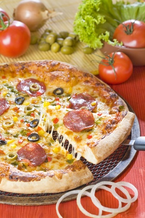A piece of pizza with hot cheese is lifting upの写真素材