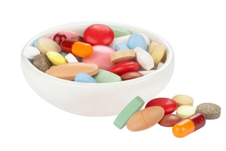 Colored pills in white bowlの写真素材