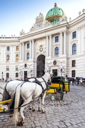 Vienna, Austria - August 30, 2013; Main entrance to Hofburg palace  Horse-drawn carts waiting for tourists at the main gate to Hofburg Palace in Viennaのeditorial素材