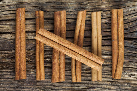 Seven cinnamon barks on the old wood backgroundの写真素材