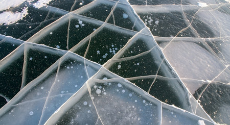 Textured surface of cracked ice. Winter scene captures frozen Lake Baikal. Unique pattern of ice formations with cold atmosphere. Natural backdrop of winter landscape. AI Generative AI generatedの素材