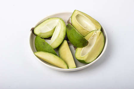 Green mangoes slices for pickle in white plateの写真素材
