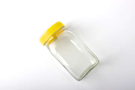 Empty transparent glass jar with yellow capの写真素材