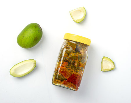 Mango Pickle jar with pieces of raw green mangoes on white backgroundの写真素材